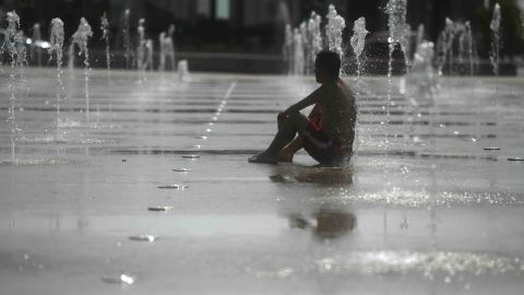 Hombre en fuente y ola de calor