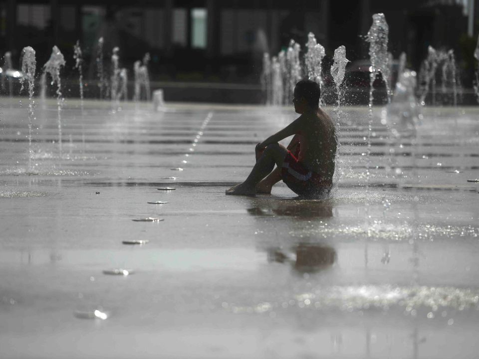 Hombre en fuente y ola de calor