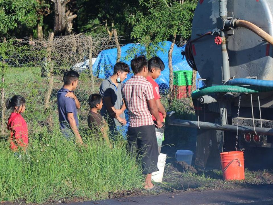 Niños recogen agua 