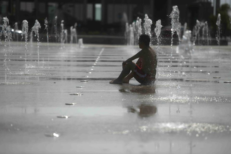 Hombre en fuente y ola de calor